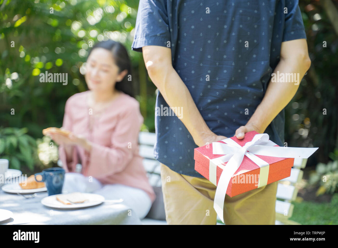 Uomo asiatico sorprendente donna nel giorno speciale. La famiglia e gli amanti del concetto. Compleanno e tema di San Valentino. - Immagine Foto Stock