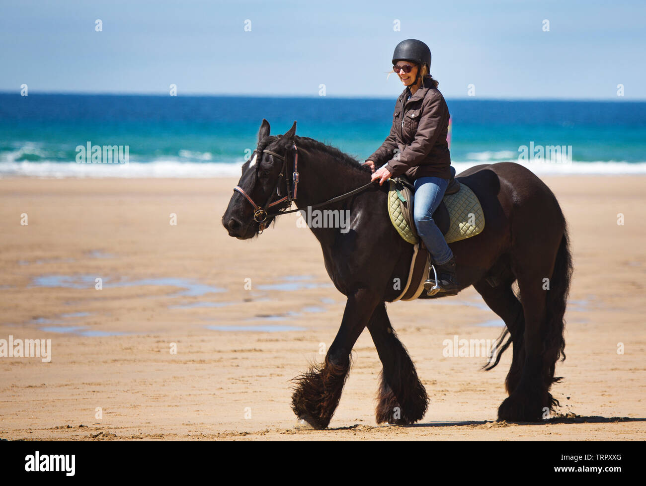 Una donna in sella ad un cavallo su una spiaggia in Cornovaglia Foto Stock