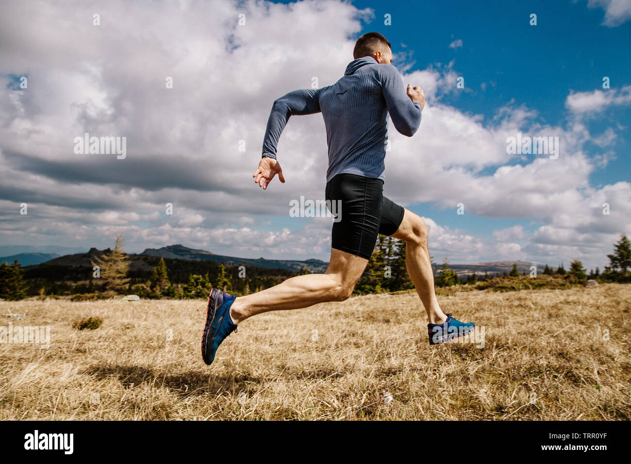 Runner maschio ad esecuzione rapida sul sentiero di montagna in estate all'aperto Foto Stock