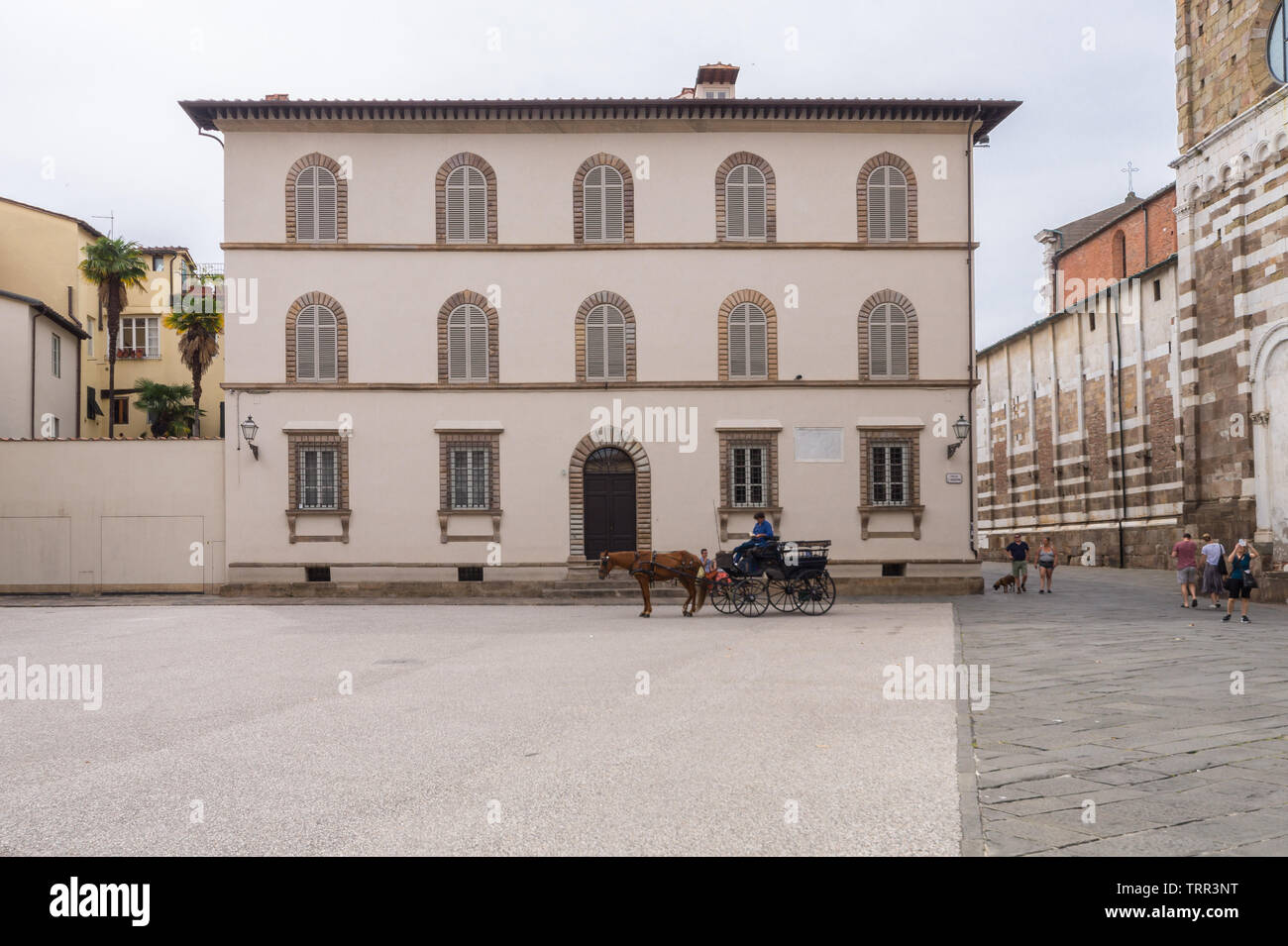 La facciata di un Italiano palazzo in stile rinascimentale nel centro storico / centro storico di Lucca, Toscana, con una carrozza trainata da cavalli Foto Stock