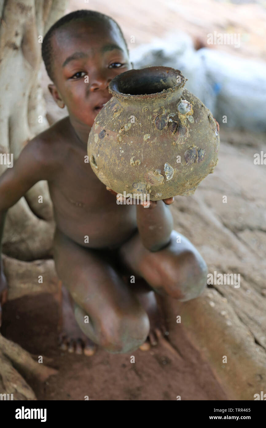 Ritratto d'onu enfant Africain montrant une jarre. Togoville. Il Togo. Afrique de l'Ouest. Foto Stock