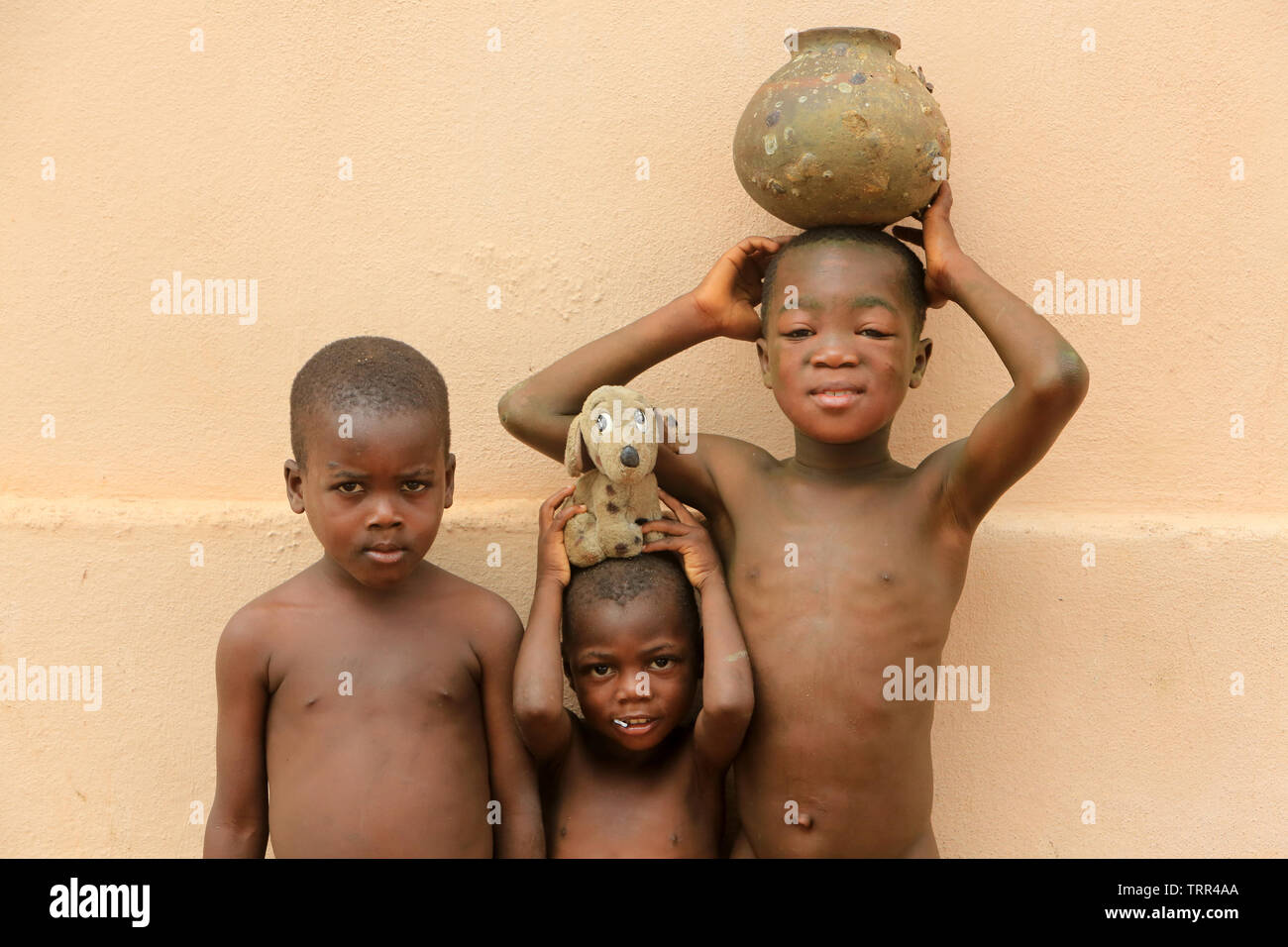 Enfants togolais portant une vasque et une peluche sur la tête. Togoville. Il Togo. Afrique de l'Ouest. Foto Stock