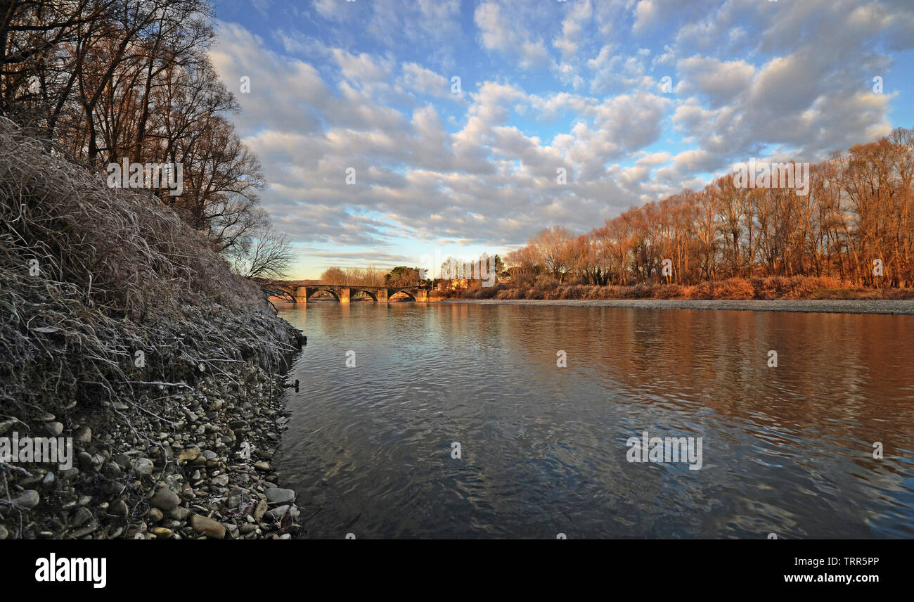 Vista panoramica del fiume Arno vicino a Ponte a Buriano il ponte medievale, ad Arezzo, Toscana, su una congelati giornata invernale, di sunrise Foto Stock