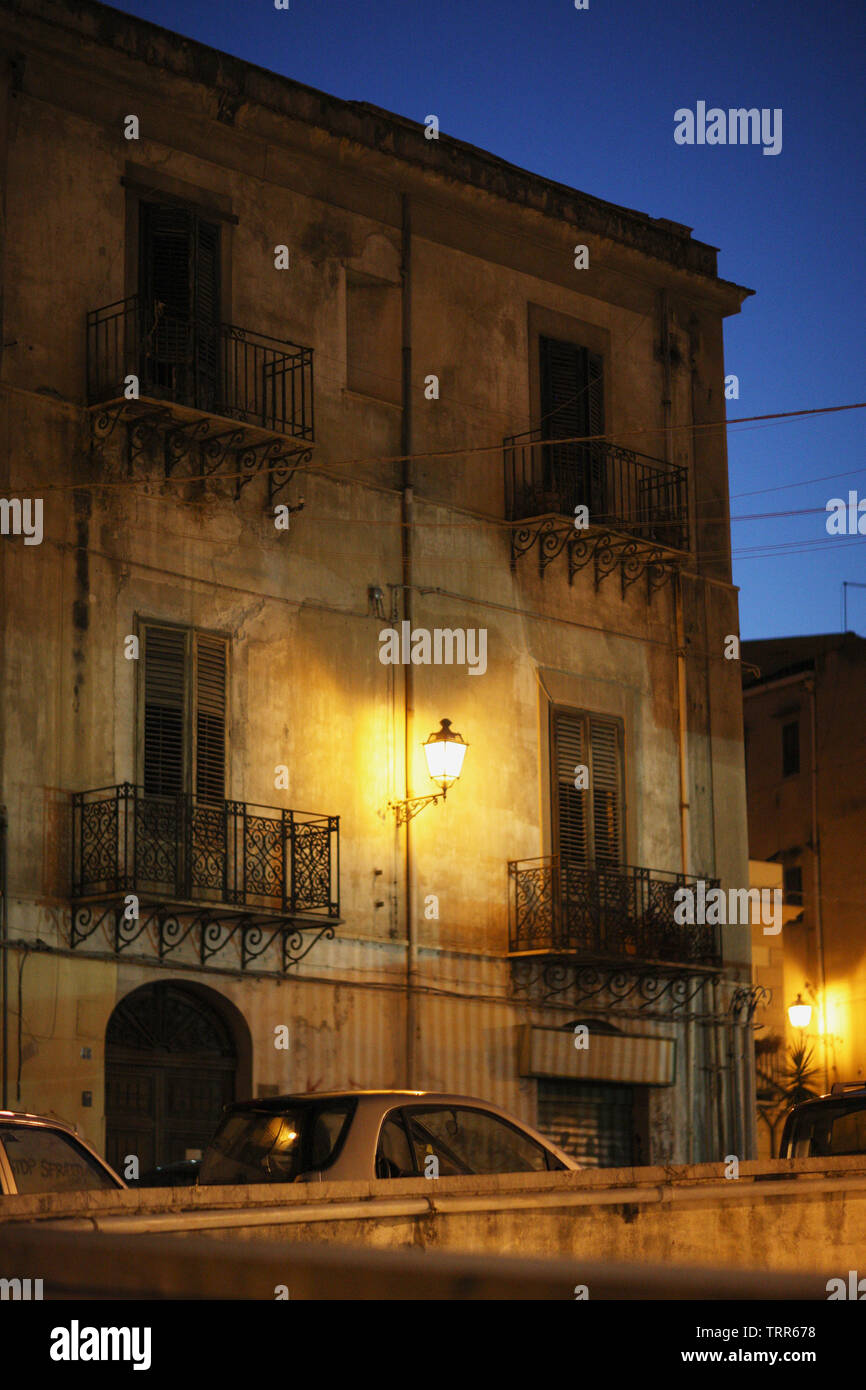 Facciata del vecchio case trasgressivi con balconi e una lanterna nel cielo notturno a Palermo, Italia. Foto Stock