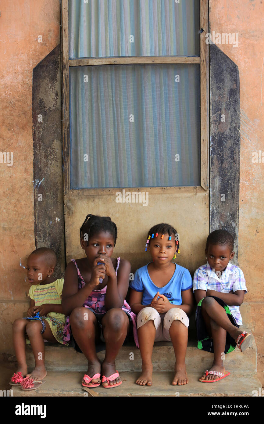 Groupe d'enfants assis sur les marche d'une dimora. La convenzione di Lomé. Il Togo. Afrique de l'Ouest. Foto Stock