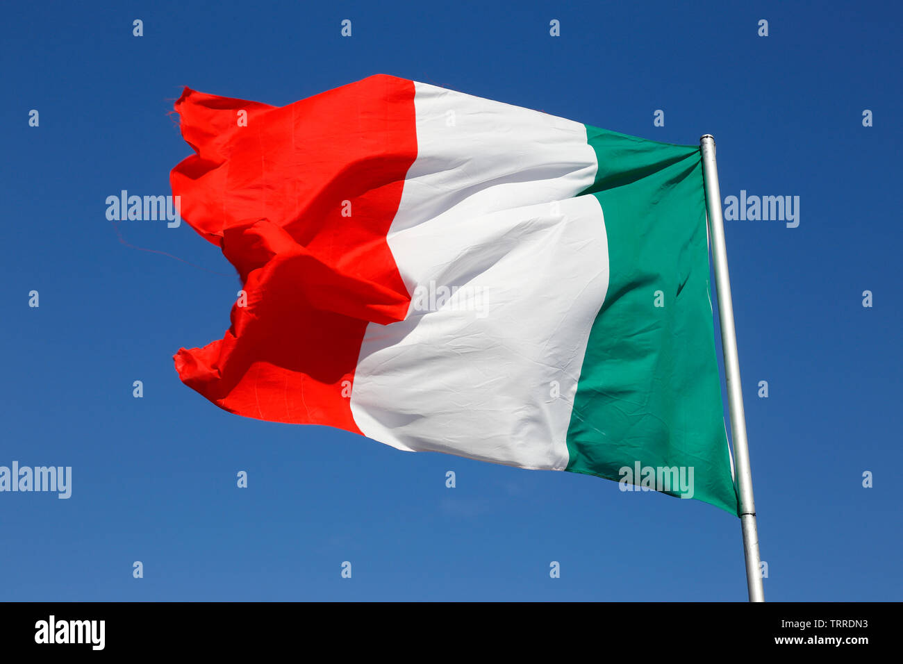 Close-up italiano della bandiera nazionale contro un cielo blu. Foto Stock