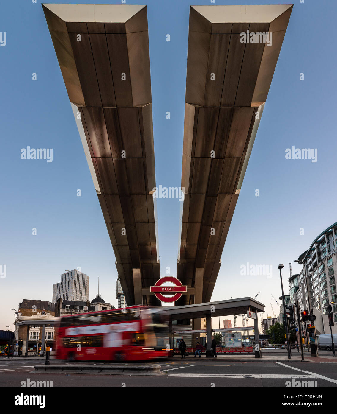 London, England, Regno Unito - 28 Maggio 2019: gli autobus passano sotto il caratteristico tetto a sbalzo della Vauxhall stazione autobus di Londra Sud al tramonto. Foto Stock