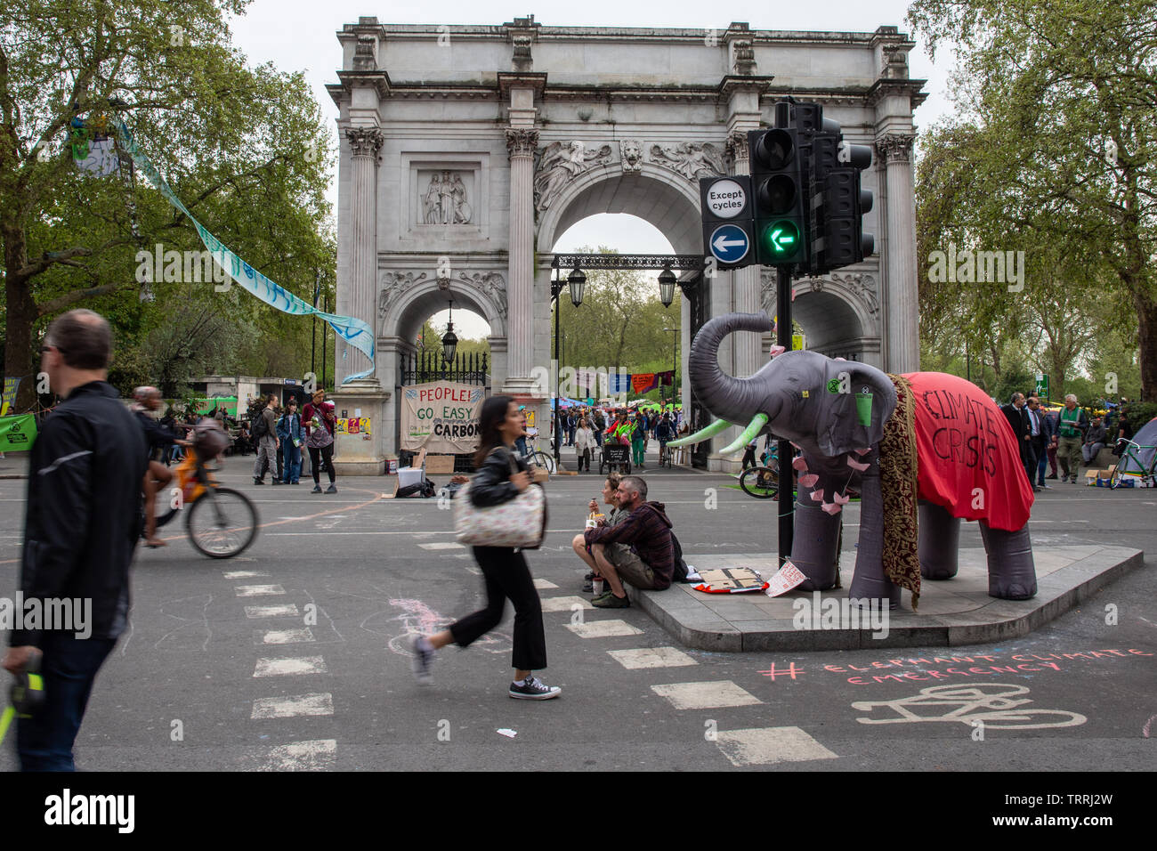 London, England, Regno Unito - 23 Aprile 2019: i ciclisti e i pedoni viaggiano attraverso un accampamento di protesta dalla ribellione di estinzione a Marble Arch, in centro a Londra. Foto Stock