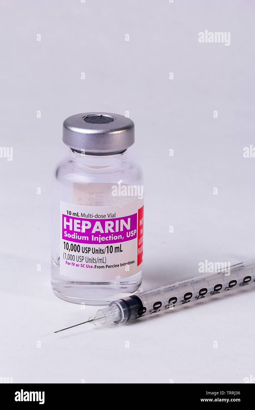 Un flacone di farmaco anticoagulante eparina sodica con una siringa su sfondo bianco Foto Stock