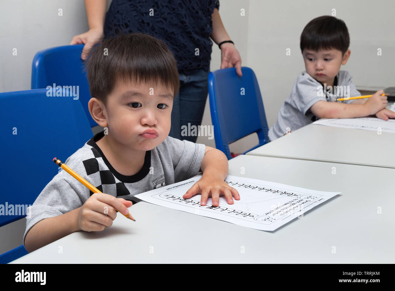 Manila, Filippine - Agosto 18, 2016: due ragazzini imparare a scrivere con una matita in aula a scuola Foto Stock