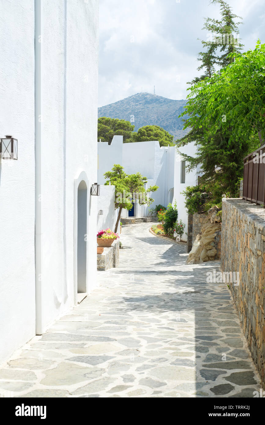 Passaggio stretto con edifici bianchi e alberi dalla Grecia Foto Stock