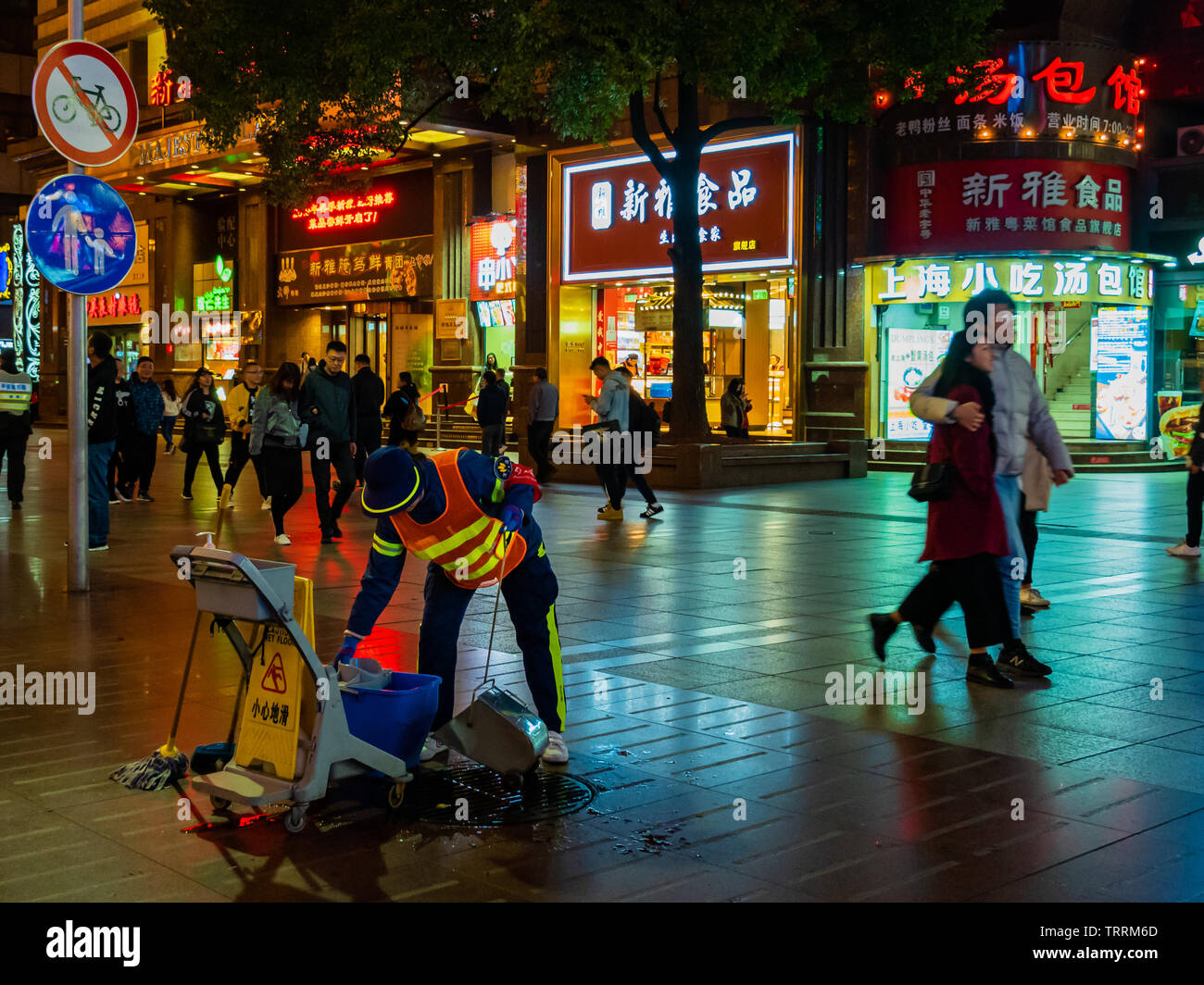 SHANGHAI, Cina - 12 MAR 2019 - una strada Cleaner pulisce il marciapiede a Nanjing East Road (Nanjing Dong Lu) strada pedonale, Shanghai, Cina alla vicina Foto Stock