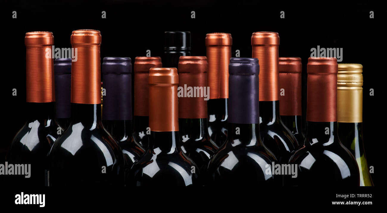Molte bottiglie di vino capi isoalted su sfondo nero Foto Stock