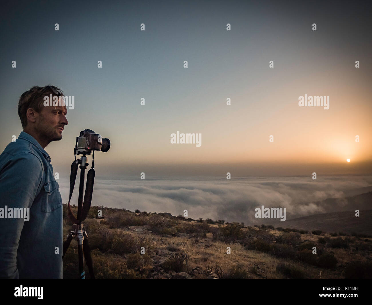 L'uomo prendendo fotografia di un bellissimo tramonto sopra le nuvole sulla cima di una montagna su La Gomera Canarie Spagna Foto Stock