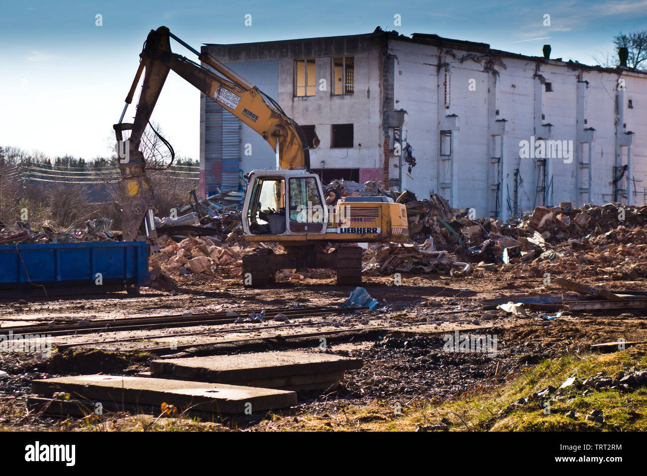 Escavatore a la demolizione di un vecchio sito industriale Foto Stock