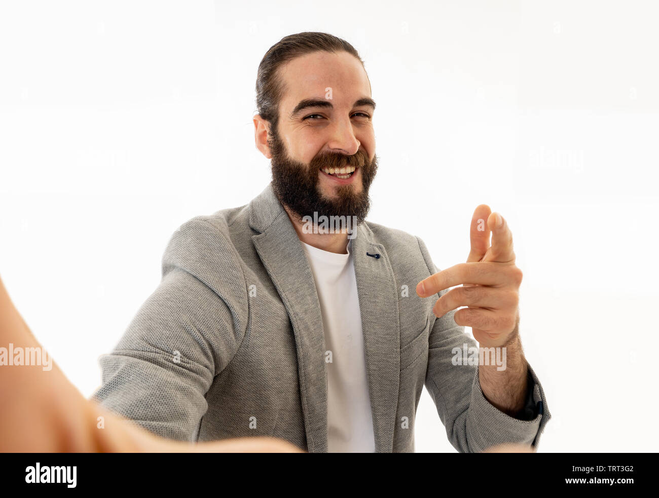 Giovani funny barbuto hipster blogger uomo in moderno stile casual tenere la fotocamera o smart phone riprese di ritratto di auto o la registrazione di video per il suo followe Foto Stock