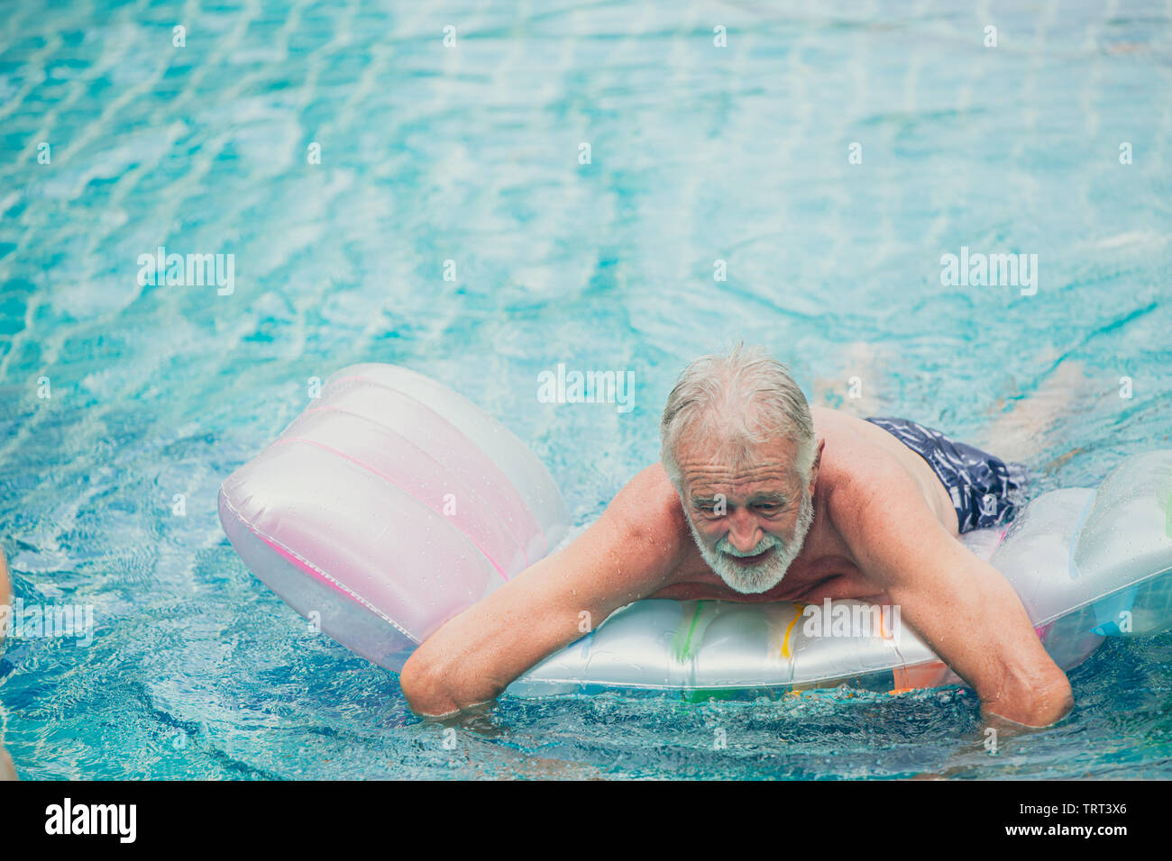 Lonely sambuco, uomo vecchio a giocare in piscina da solo presso la casa di cura con umore triste infelice emozione Foto Stock