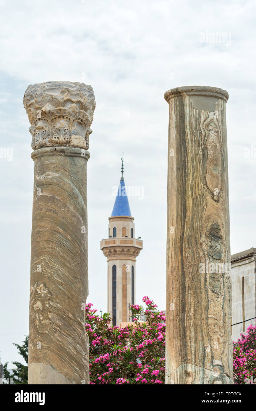 Colonne romane e una moschea il minareto, Al Mina sito archeologico, pneumatico, Libano Foto Stock