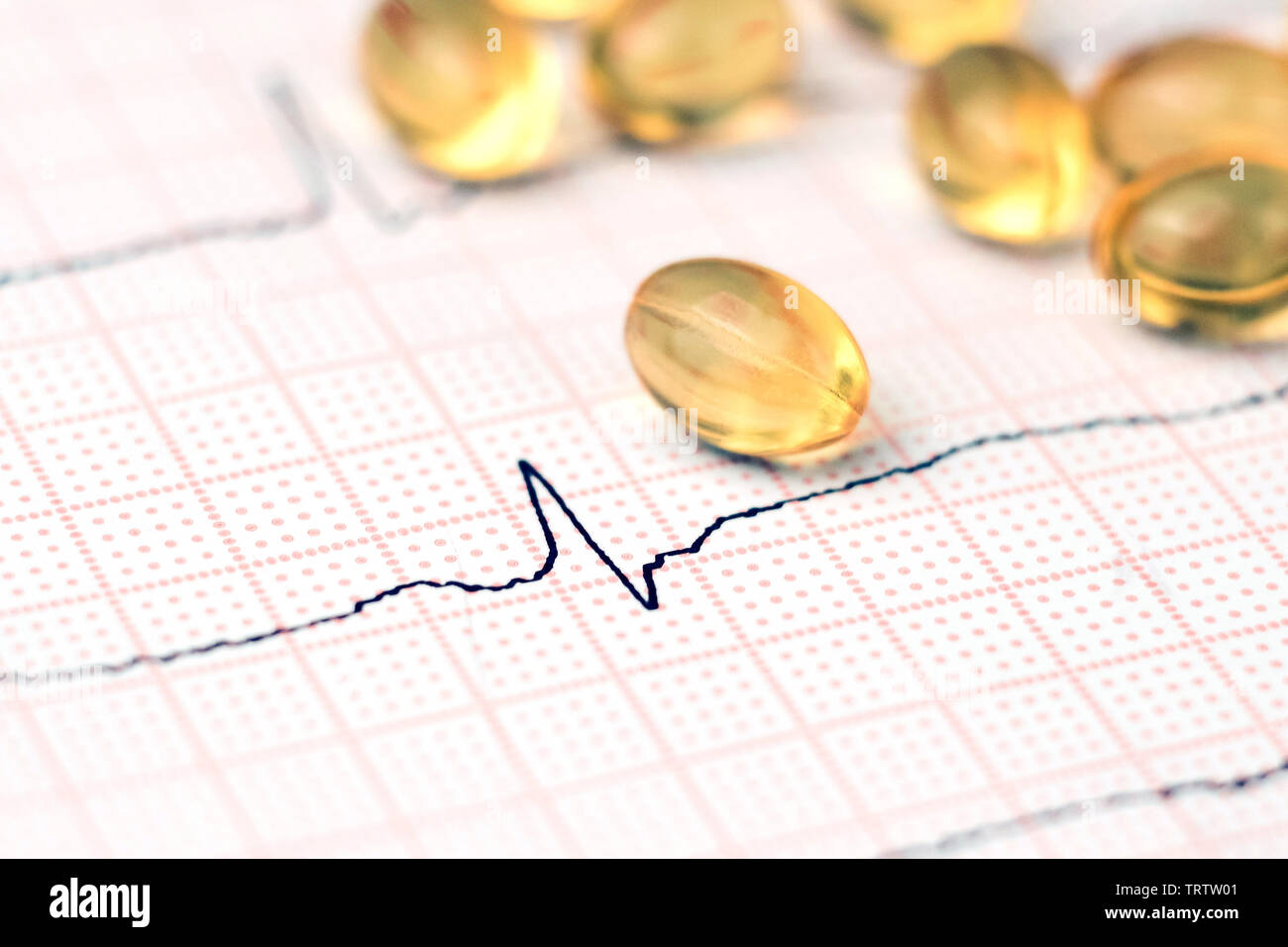 Olio di pesce capsule su un sfondo cardiogram. cuore sano concetto Foto Stock