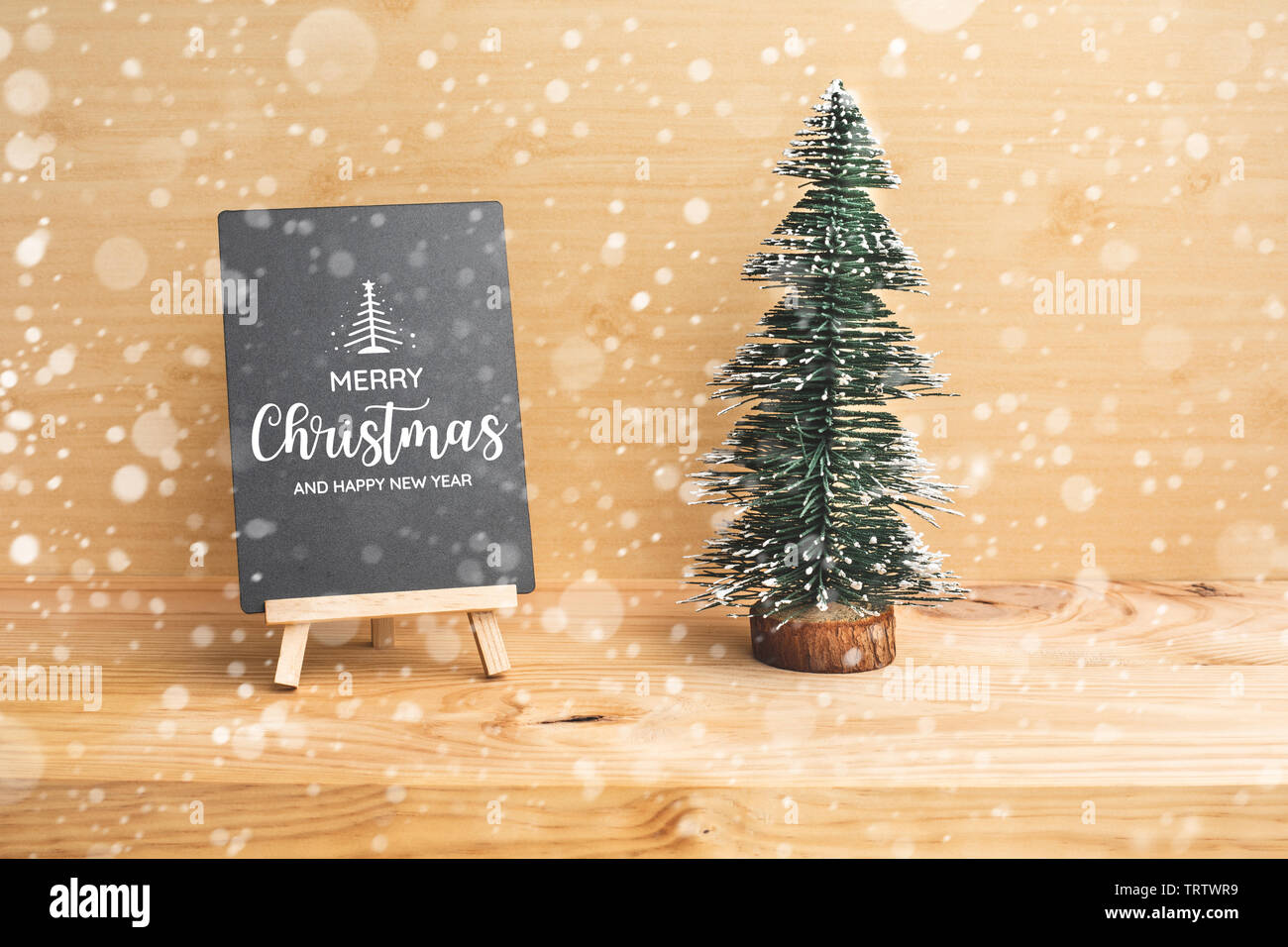 Carino pino mock up con etichetta nera sul tavolo di legno sfondo.Buon Natale e concetti d'inverno idee.Stile minimal Foto Stock