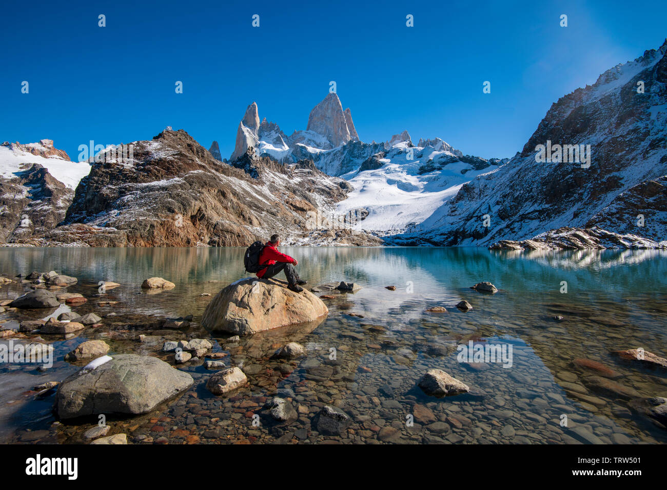 Escursionista sat ammirando la vista del monte Fitz Roy e Cerro Torre con Lago de los Tres, El Chalten, Patagonia, Argentina. Foto Stock