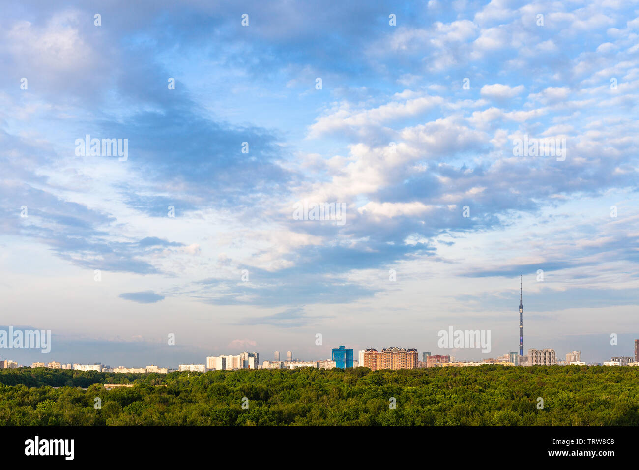 Pomeriggio estivo cielo blu con nuvole sulla foresta verde e case urbane nella città di Mosca Foto Stock