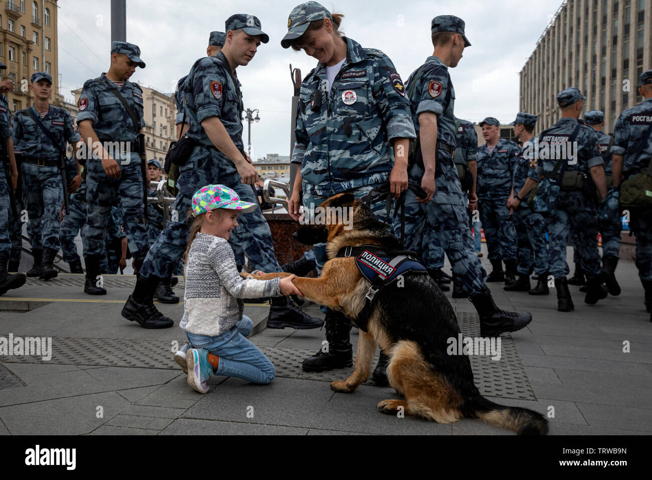 Mosca, Russia. Xii Giugno, 2019 Una ragazza scuote la zampa di un cane di polizia sulla Tverskaya Street durante un'opposizione non autorizzato nel rally di Mosca, Russia Foto Stock