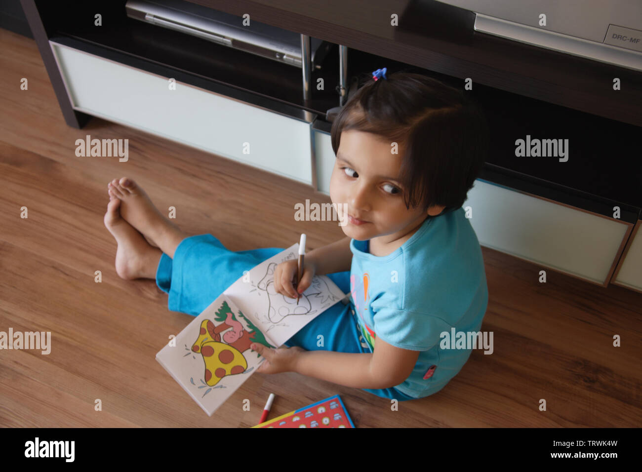 Elevato angolo di visione di una ragazza di colorazione in un libro Foto Stock