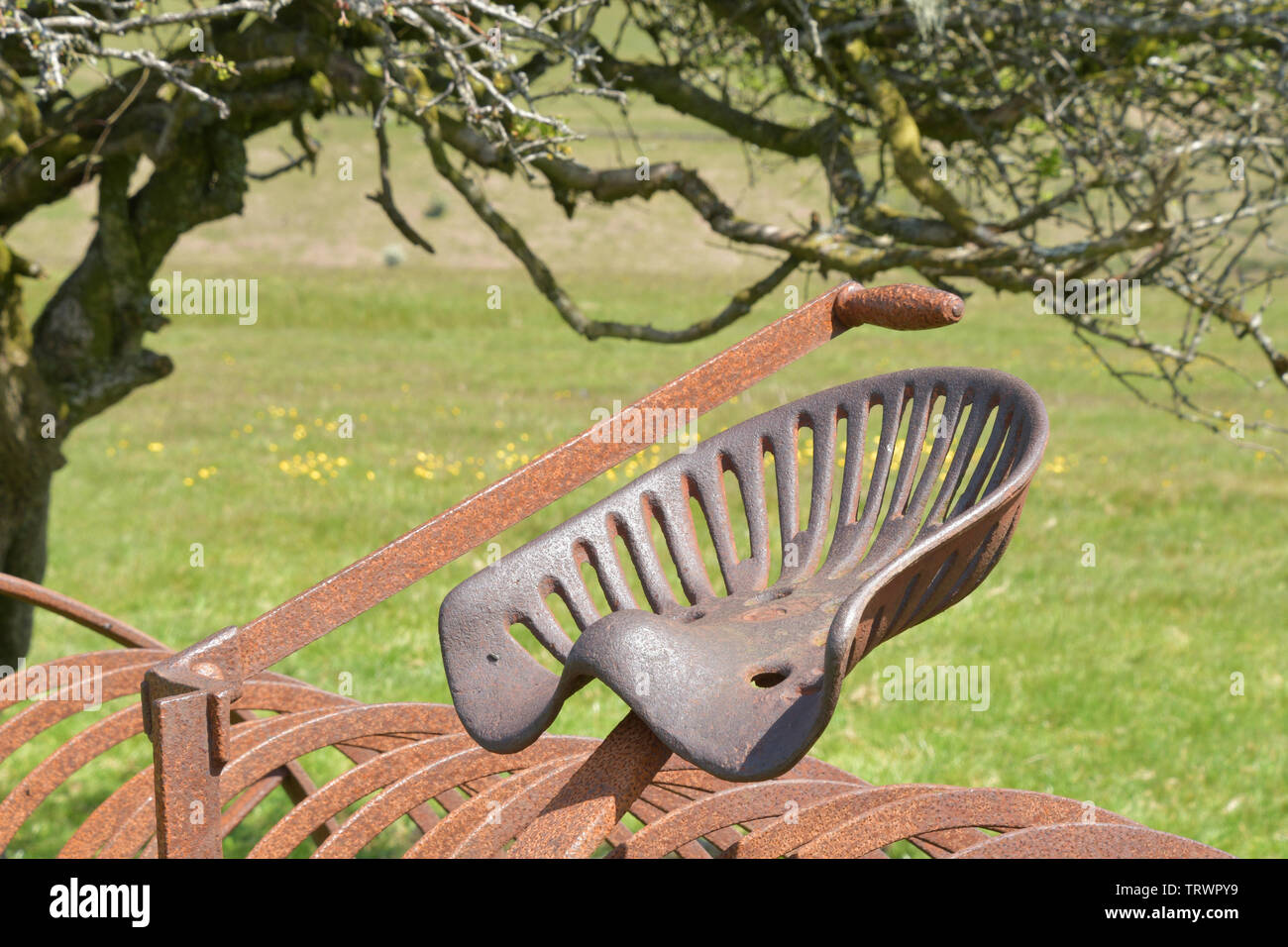 Il sedile e la leva di sollevamento su un angolo di spoglia di fieno si ritirò in un campo su Exmoor, convertito da cavallo al trattore alimentato. Exford, Somerset REGNO UNITO Foto Stock