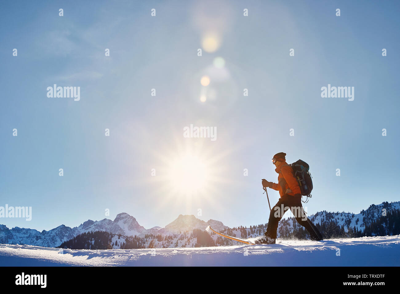 L'uomo sciare sulla polvere fresca neve a montagne contro il cielo sereno vicino a Almaty, Kazakhstan Foto Stock
