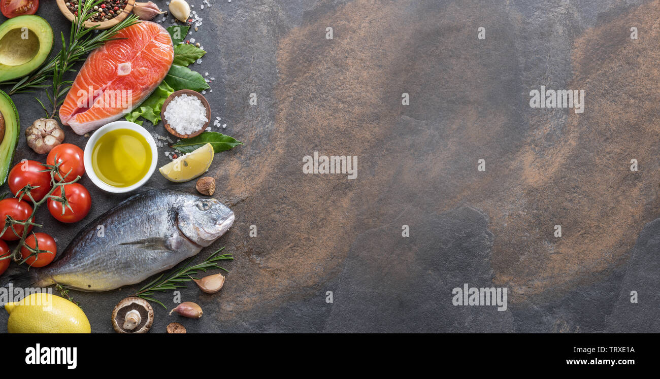 Materie dorado pesce e bistecca di salmone con spezie e verdure sulla scheda di grafite. Vista dall'alto. Foto Stock