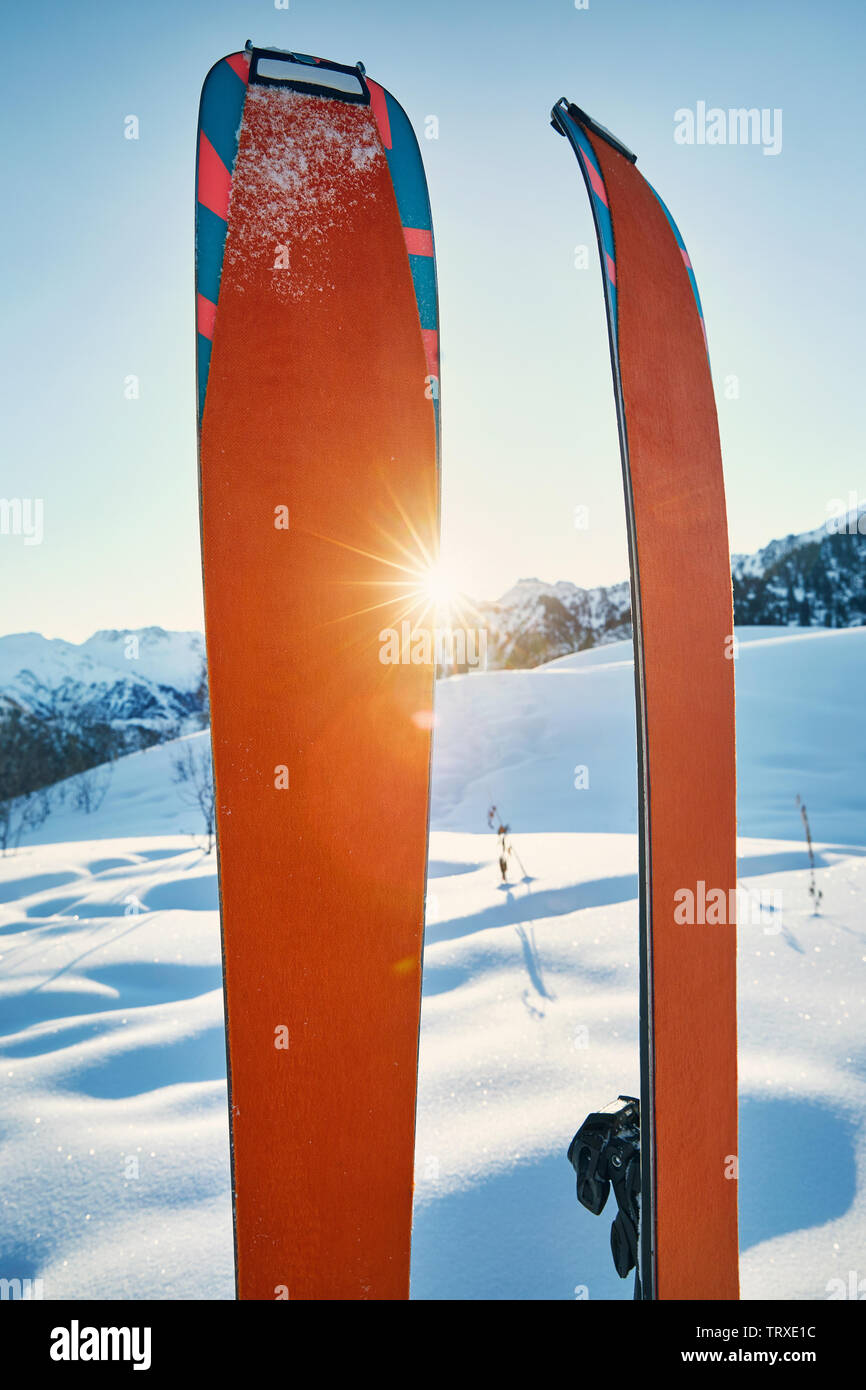 Coppia di sci nella neve con orange camus alla mattina di sole in montagna Foto Stock