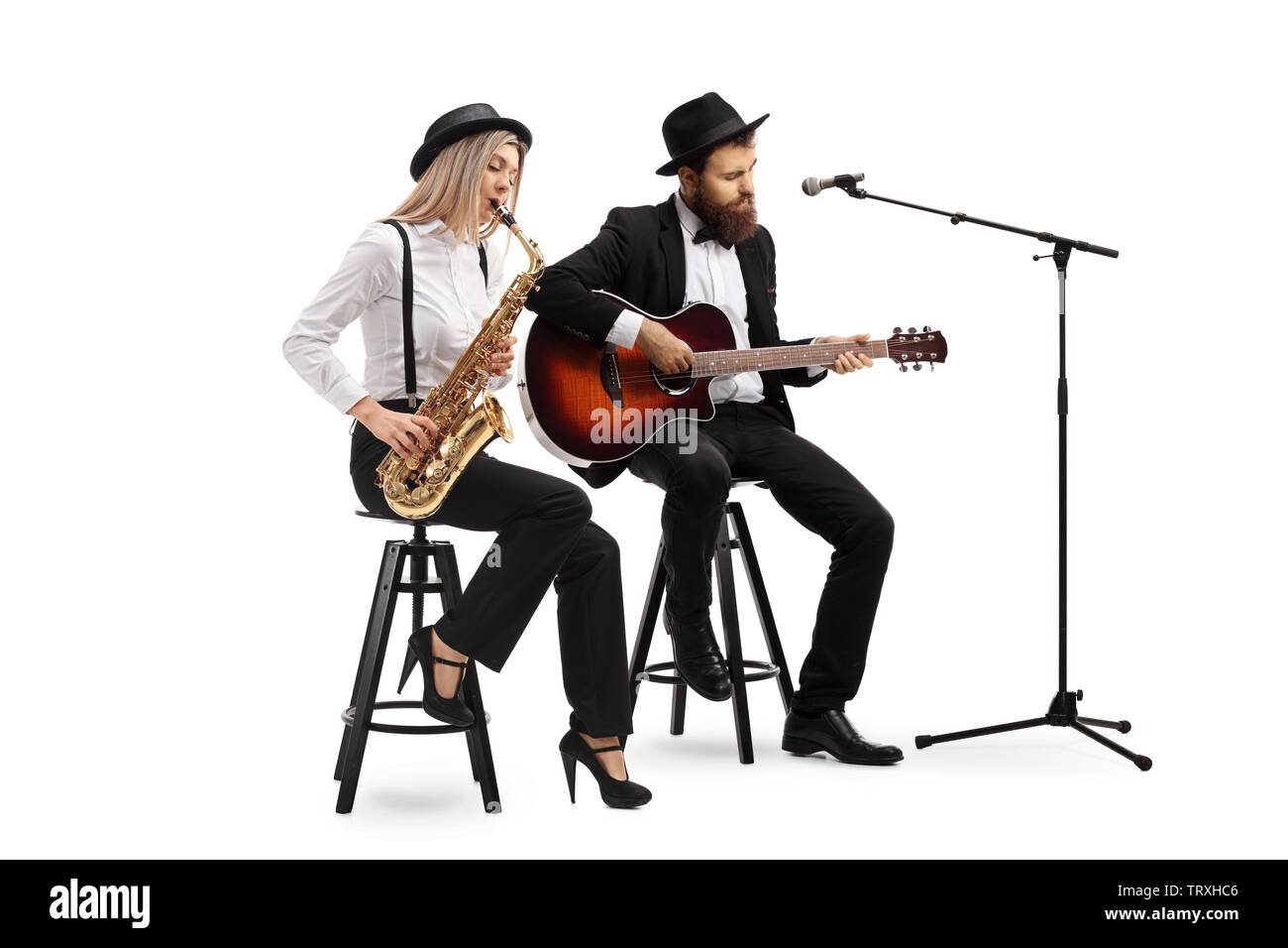 A piena lunghezza shot di una giovane donna che gioca il sax e un uomo suonando una chitarra acustica isolati su sfondo bianco Foto Stock