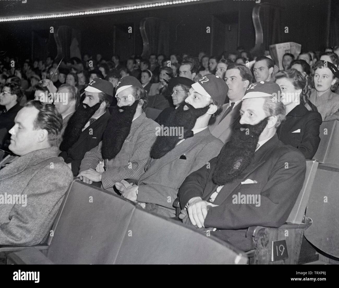 Udienza nel 1940s. Un gruppo di quattro uomini sono seduti in un cinema, tutti indossano false barbe. La Svezia 1948. Kristoffersson ref AP100-3 Foto Stock