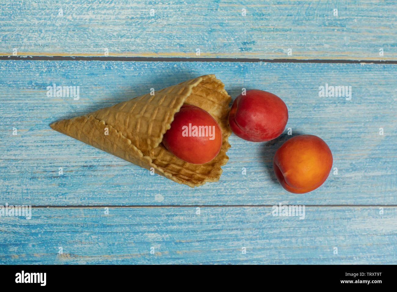 Frutta di stagione. Gelato di frutta. Albicocca in una torta di mele su un blu sullo sfondo di legno. Foto Stock