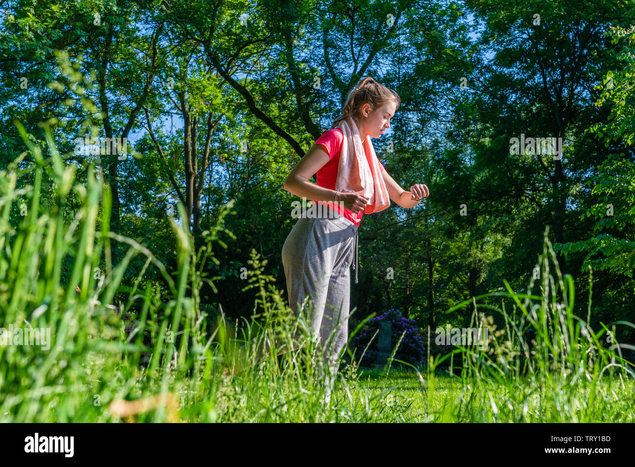 Un pareggiatore di giovani in natura controlla il suo impulso sul suo orologio fitness Foto Stock