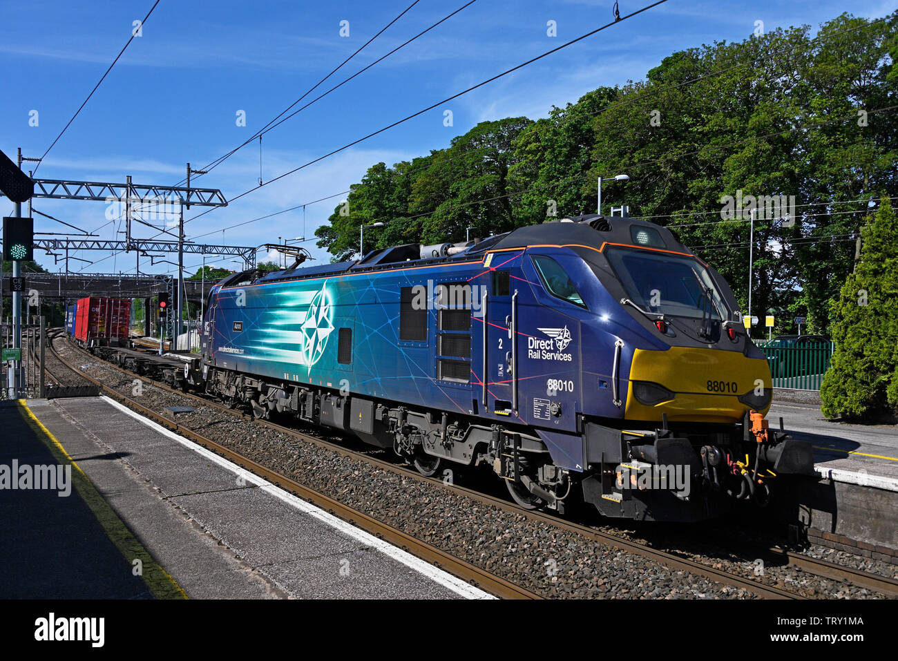 Direct Rail Services Class 88 locomotore No.88010 "Aurora" alaggio trasporto misto merci sulla costa ovest Mainline. Oxenholme, Cumbria, England, Regno Unito Foto Stock