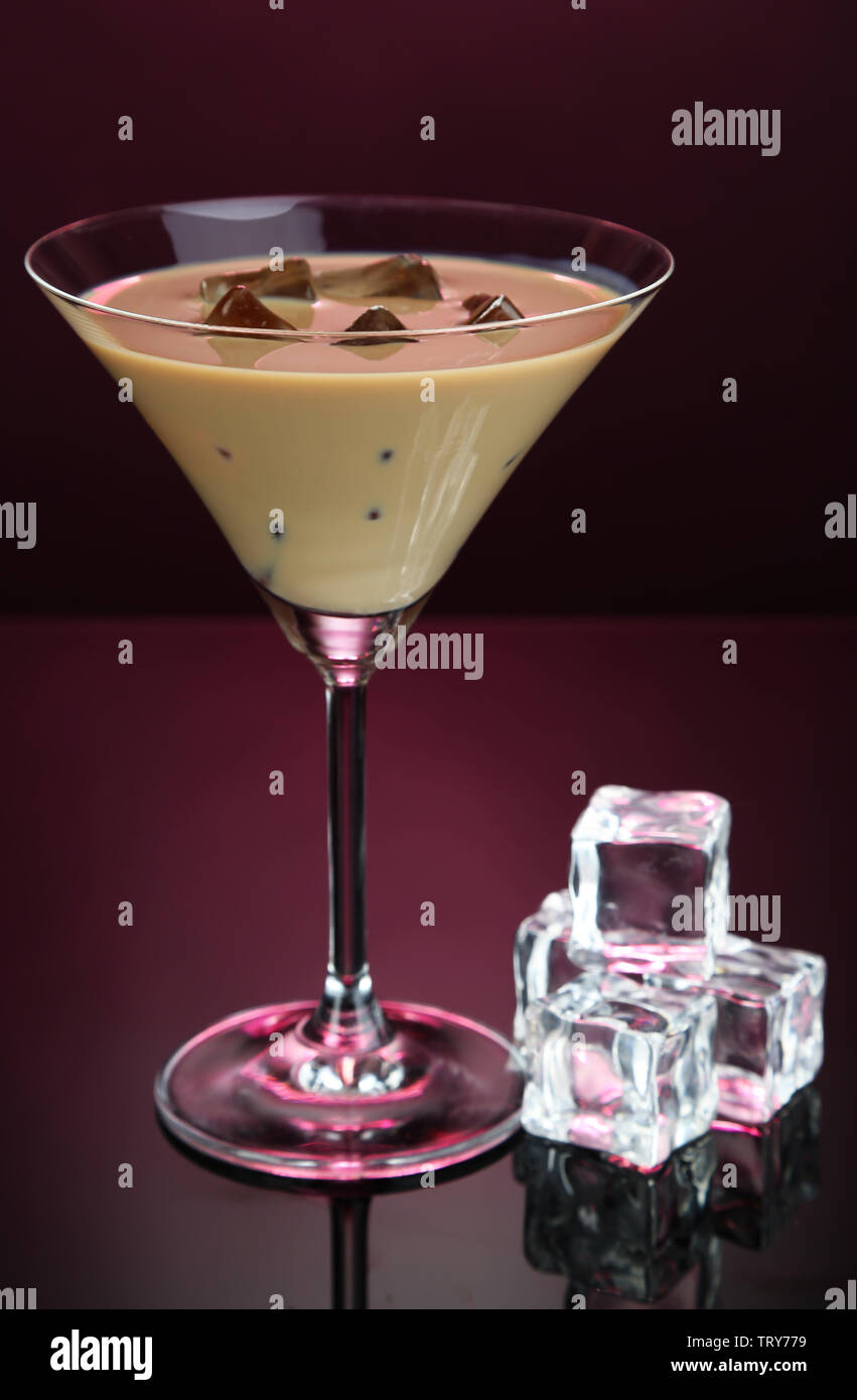 Il Baileys liquore in vetro su sfondo rosa Foto Stock
