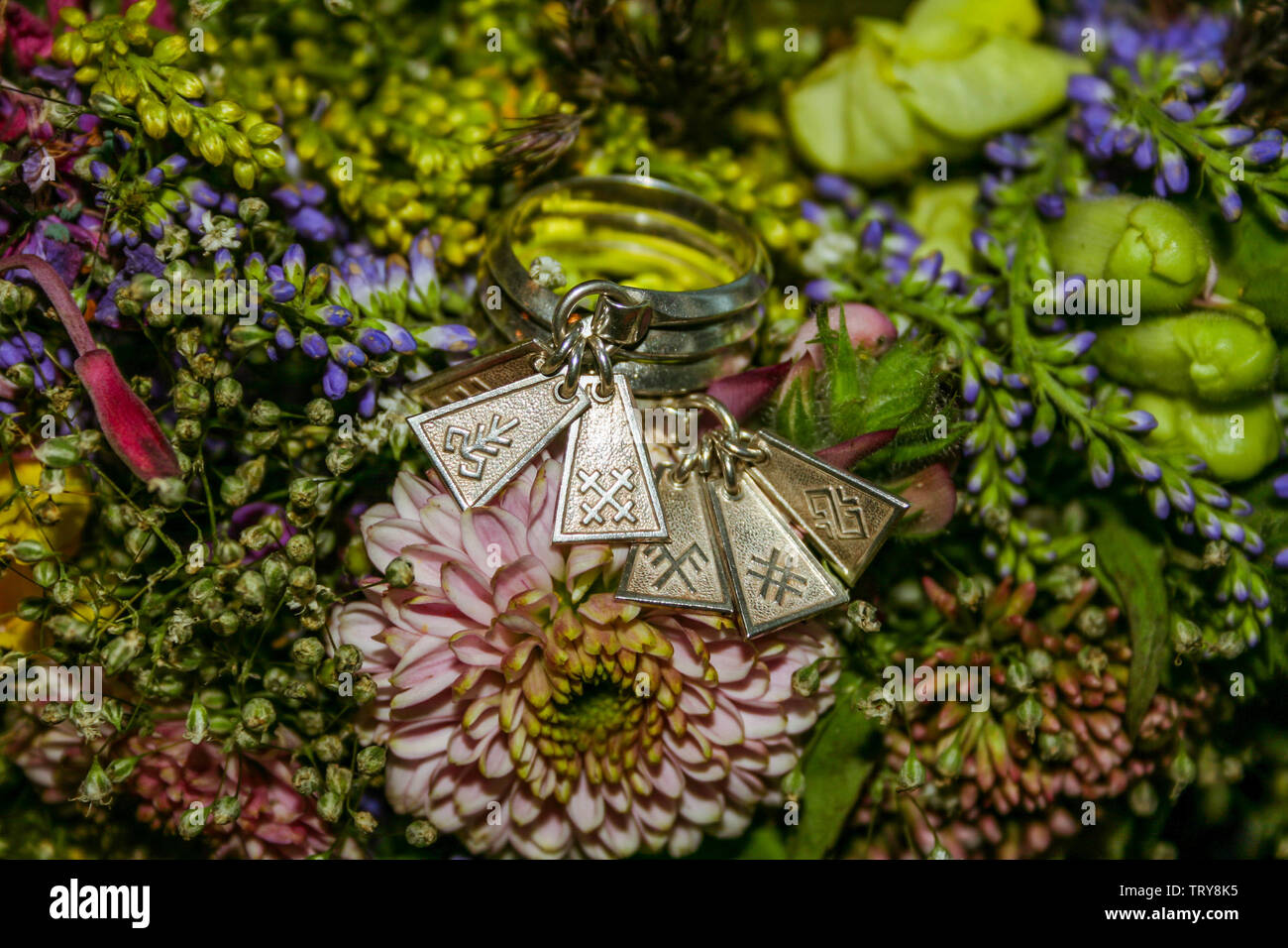 Il lettone tradizionale celibi donna anello in argento o sette giorno/anello di fidanzamento con segni lettone su un mazzo di fiori. Foto Stock