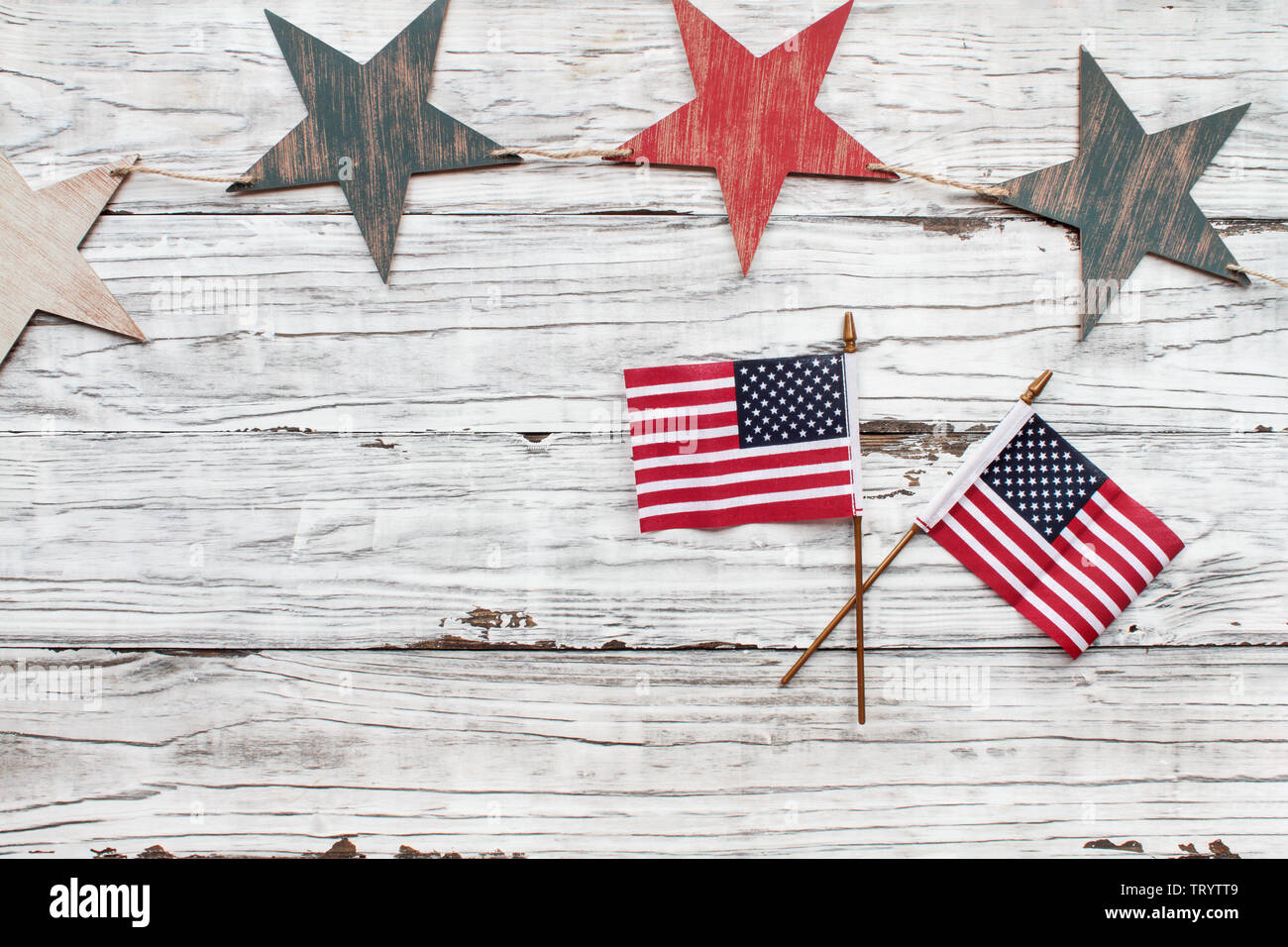 Quarto di luglio dello sfondo. Stelle di legno con bandierine americane su un bianco sfondo rustico per celebrare l'America il giorno di indipendenza. Foto Stock