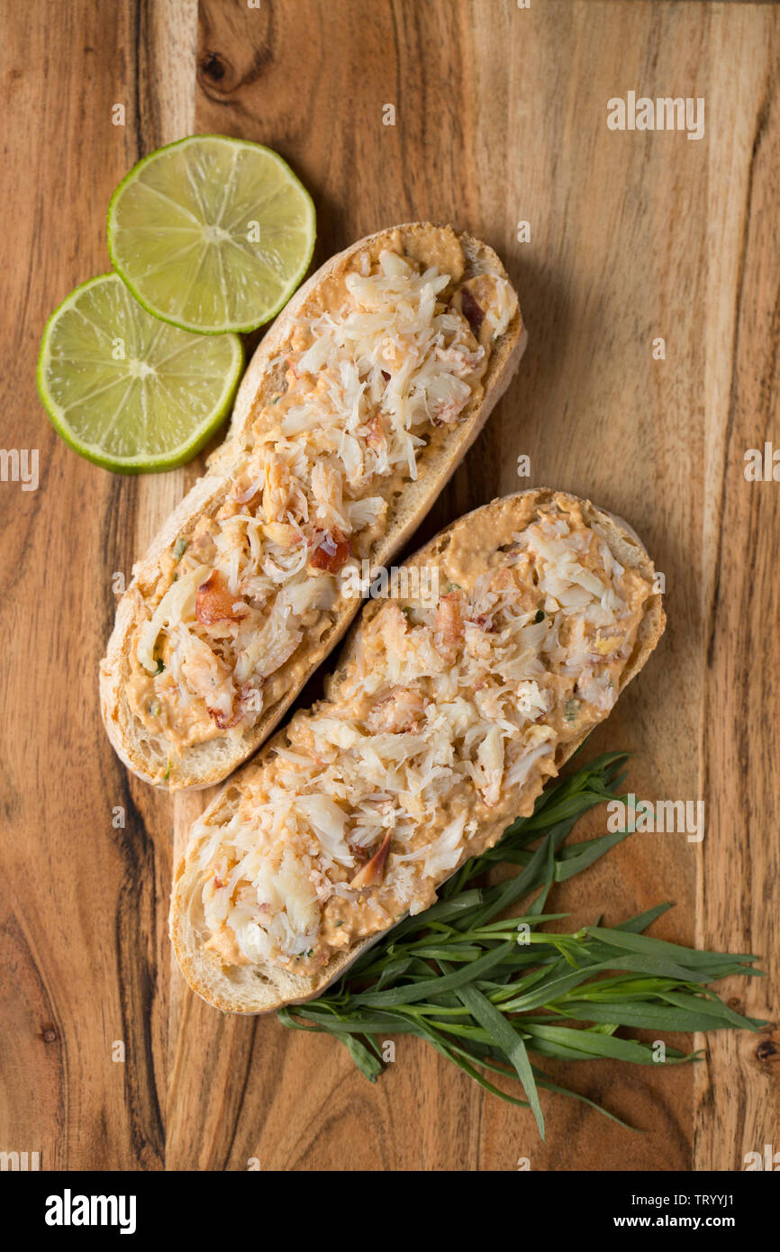 Due open crab sandwich fatti dal marrone e bianco di carne commestibile, o marrone, granchio, Cancer pagurus. La carne di colore marrone è stato miscelato con mayonnais Foto Stock