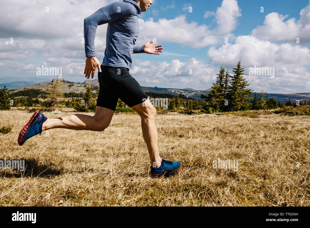 L'uomo runner trail running su erba gialla sull altopiano di montagna Foto Stock