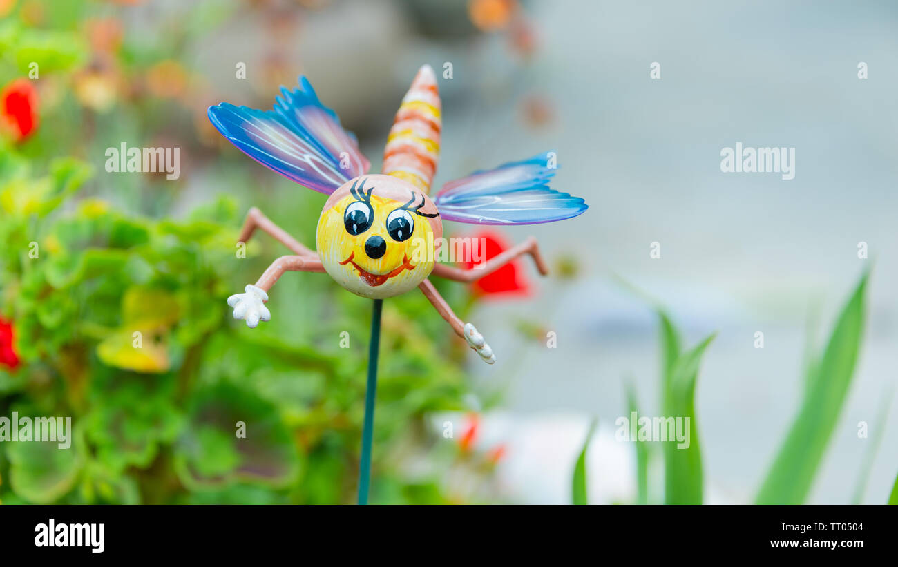 Una novità ornamento giardino posizionato su uno stelo in un letto di fiori in un giardino interno Foto Stock