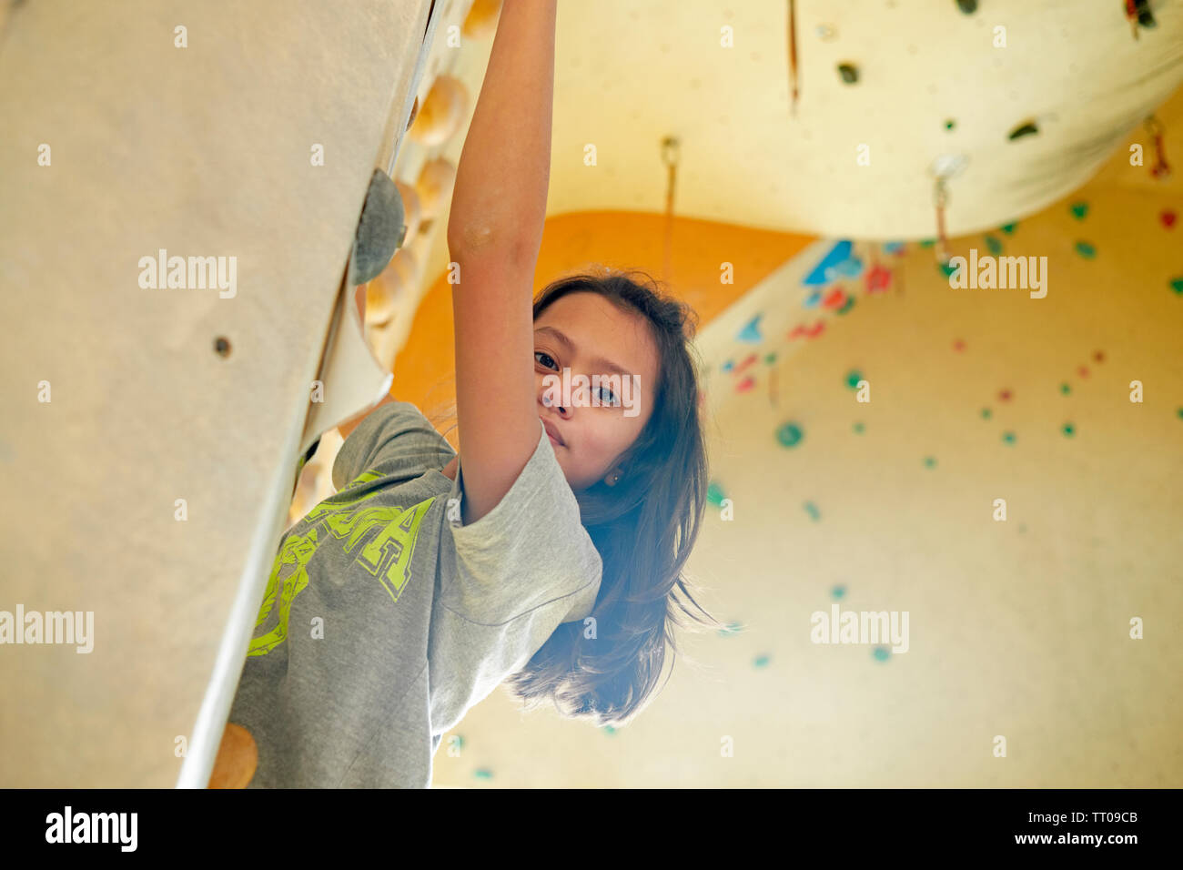 Ragazza giovane la scalata all'interno di una arrampicata di apprendimento di nuove capacità Foto Stock