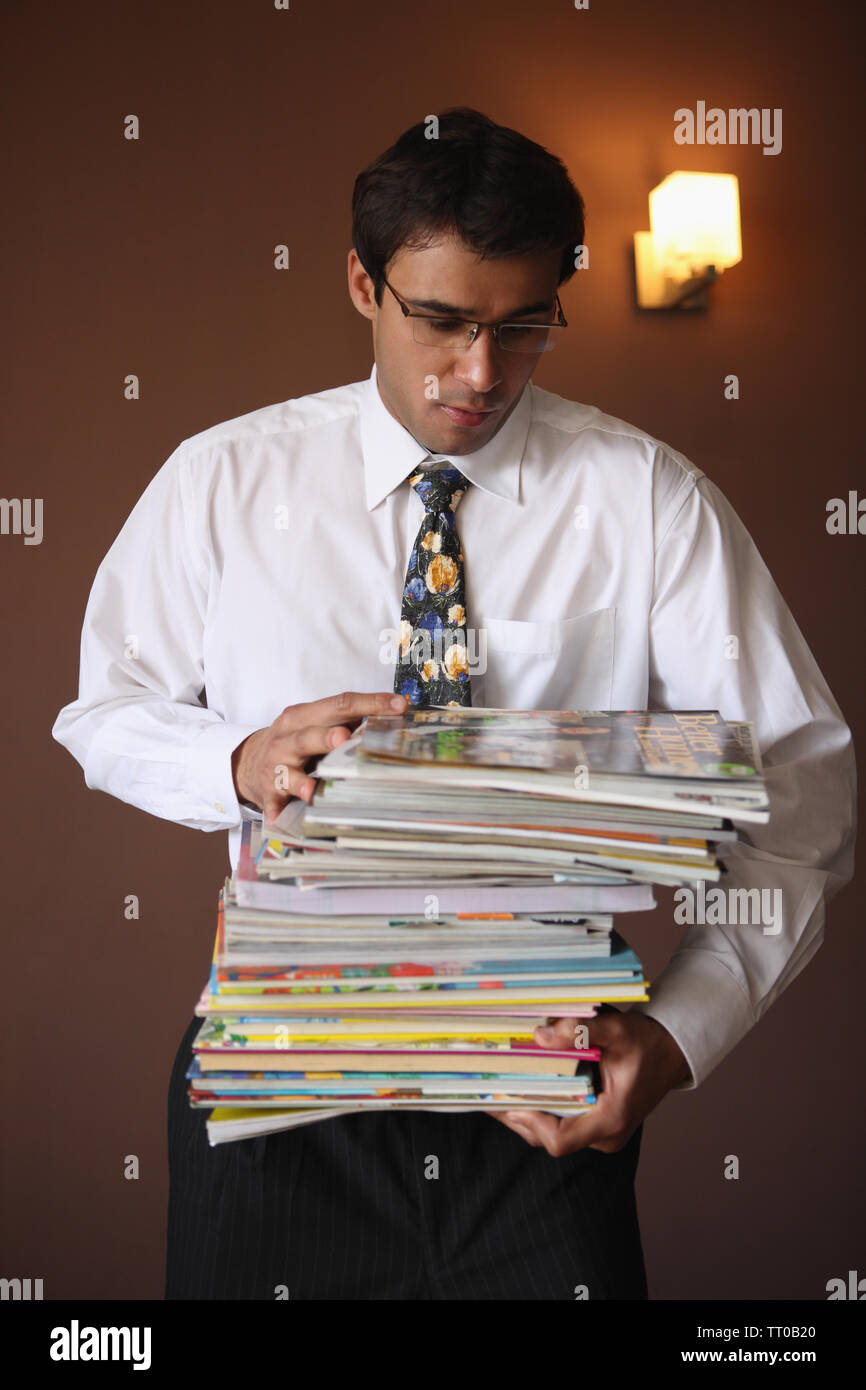 Commerciante indiano che trasportano pila di libri Foto Stock