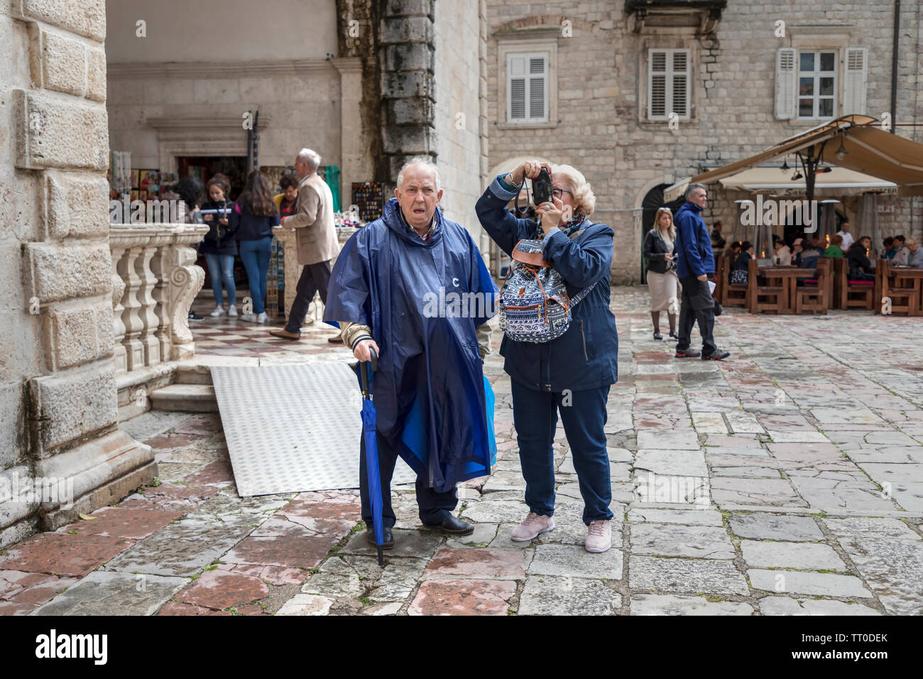 Montenegro, 30 Aprile 2019: scene di strada con una coppia senior di turisti in piedi presso la piazza e le visite turistiche intorno alla città vecchia di Kotor Foto Stock
