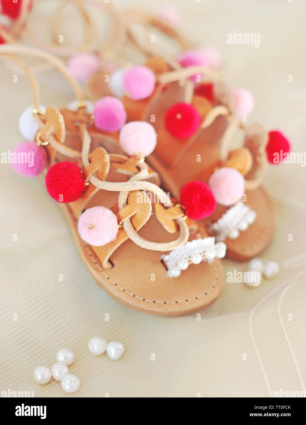 Il greco sandali di cuoio per le ragazze con colorati pom pom - gladiator  sandals - scarpe per bambini annuncio Foto stock - Alamy