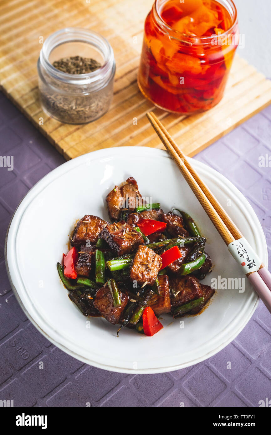 Agnello con cumino, fagioli verdi e pepe rosso Foto Stock