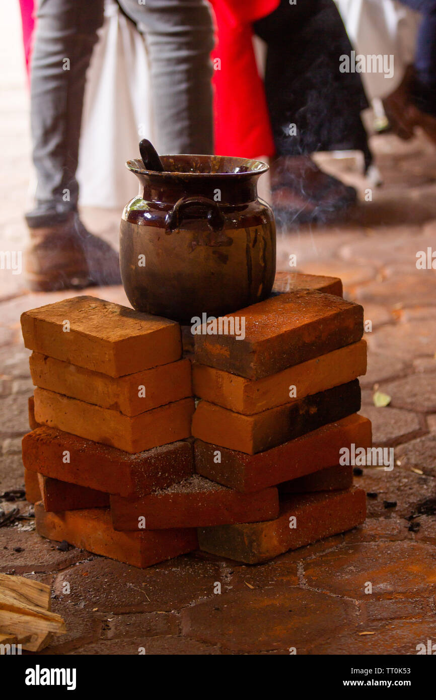 Un messicano artigianale di pentola di creta su tre pietre sparò stufa a legna Foto Stock