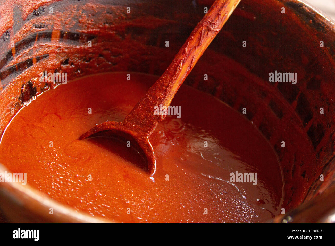 Vista dall'alto di un messicano artigianale di pentola di creta con mole e un cucchiaio di legno Foto Stock